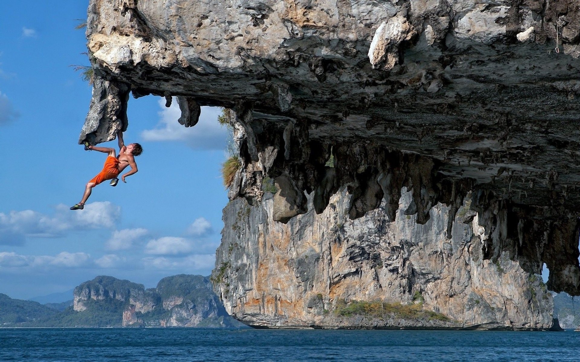  a human fly climbing an overhanging cliff