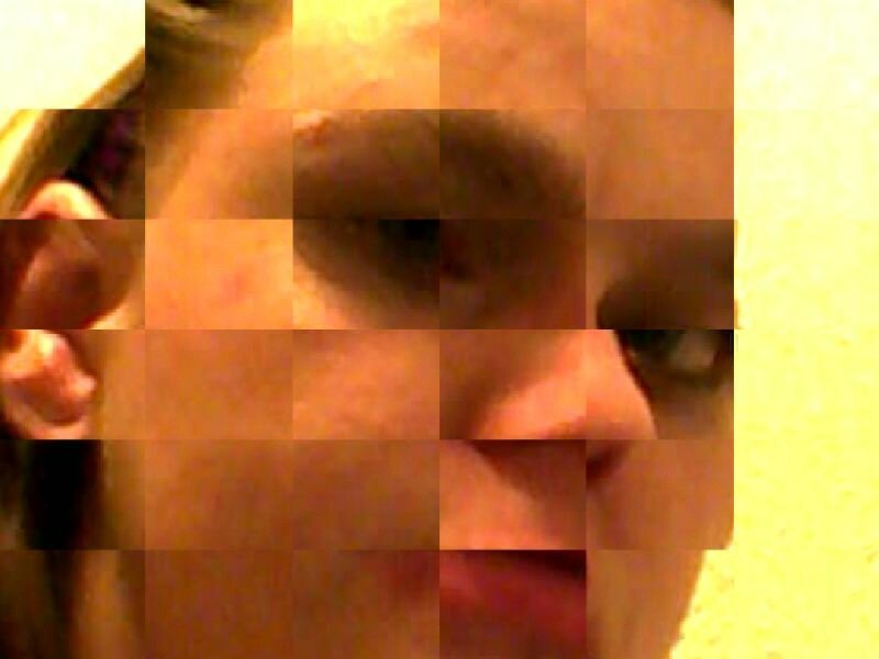 Close-up of a woman's face rendered in a grid of square tiles, creating a pixelated collage; she looks slightly to the side with a neutral expression.