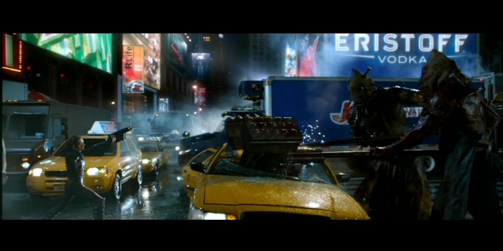 Scene from the movie Resident Evil: Retribution showing a rainy city street at night with yellow taxis and shadowy figures near a damaged car.
