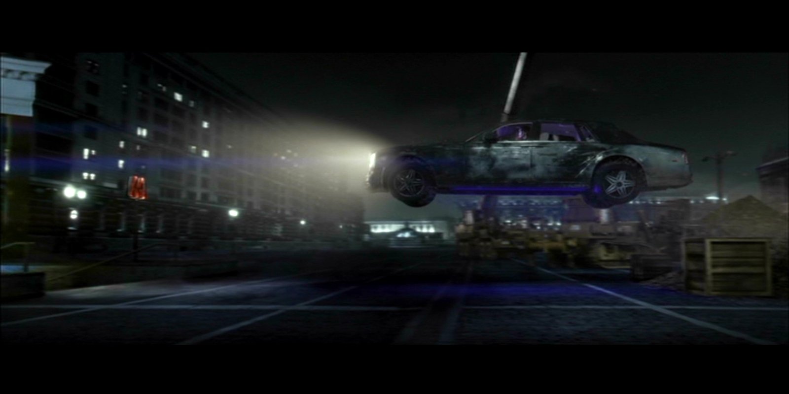 A dark urban scene from the movie Resident Evil: Retribution shows a car suspended mid-air, illuminated by a bright spotlight in a foggy night setting.