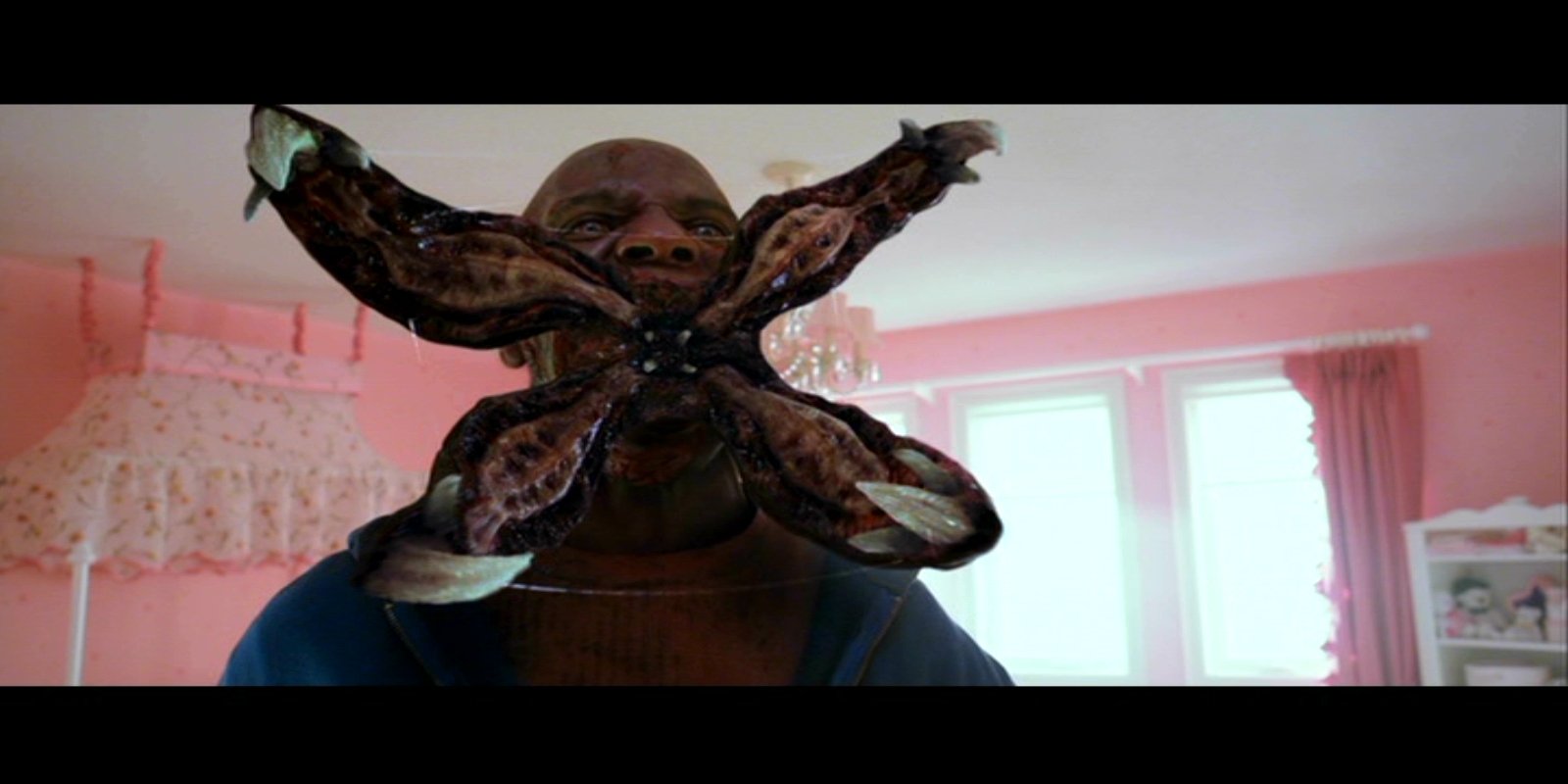 A scene from the movie Resident Evil: Retribution showing a creature attached to a person's face in a brightly lit room.