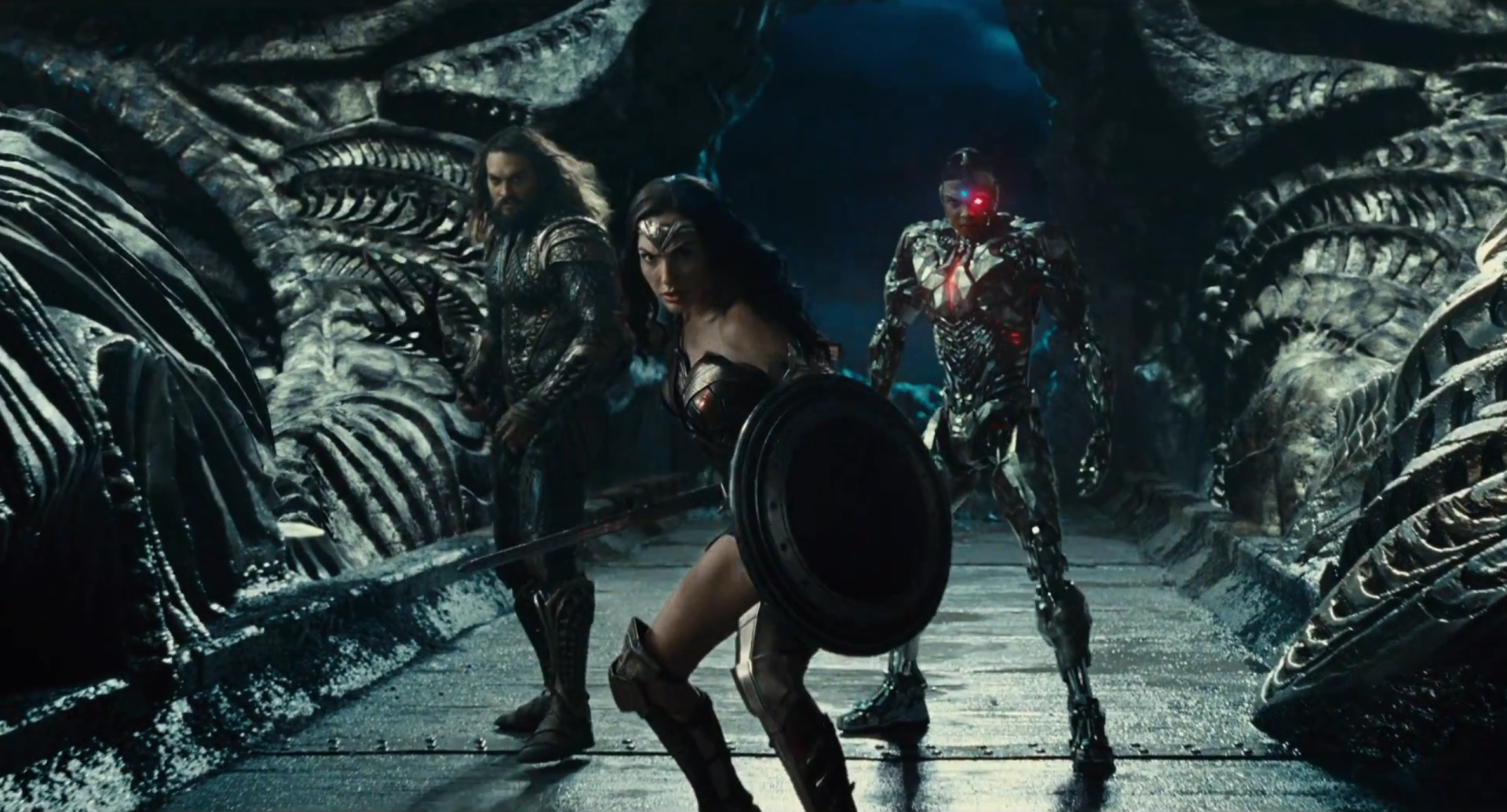 Aquaman, Wonder Woman, and Cyborg stand ready in a dark, intricate setting from the 2017 Justice League movie by DC Comics, featuring Jason Momoa, Gal Gadot, and Ezra Miller.