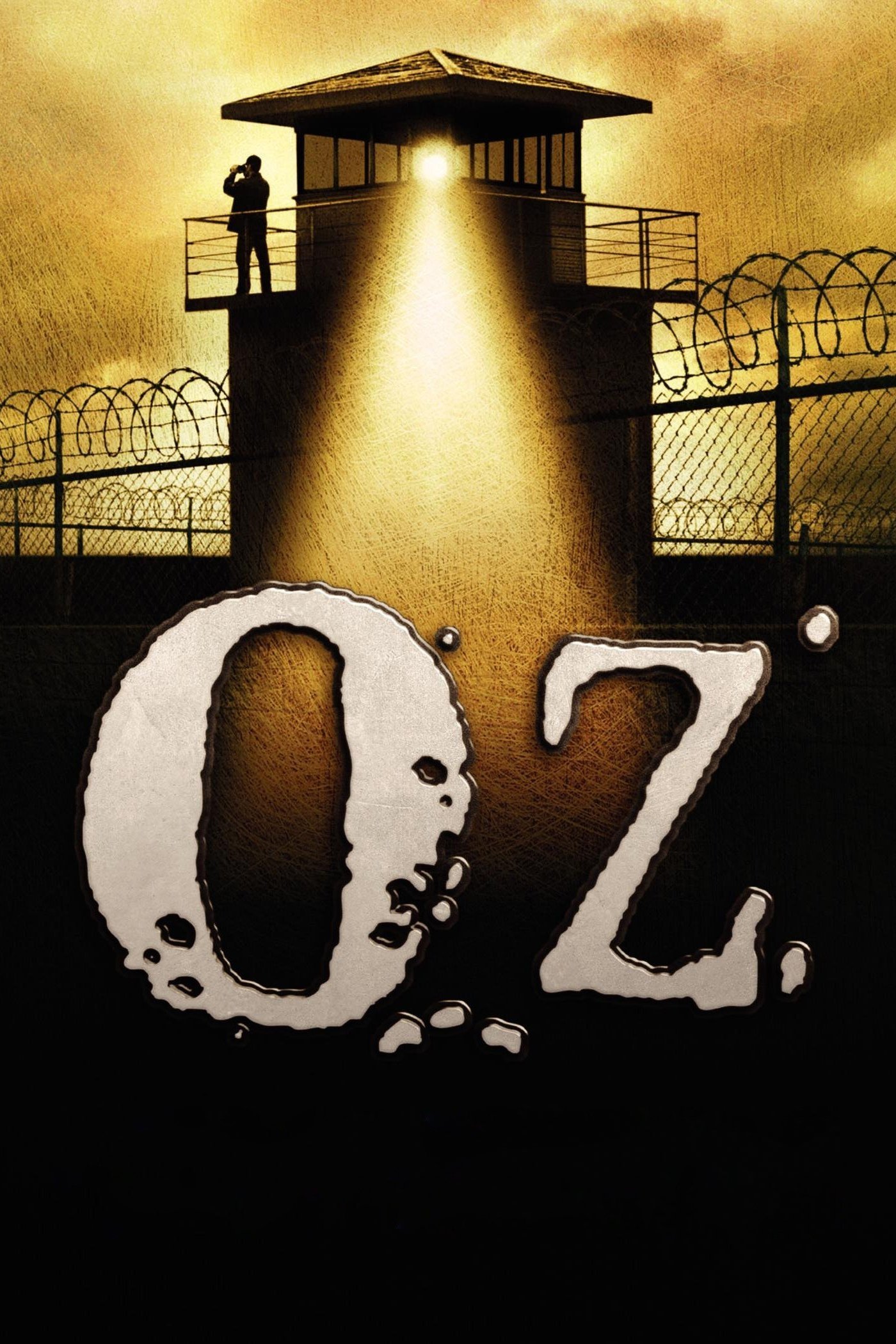 TV show Oz poster: spotlighted prison guard tower and barbed-wire fences looming over a large distressed Oz title.