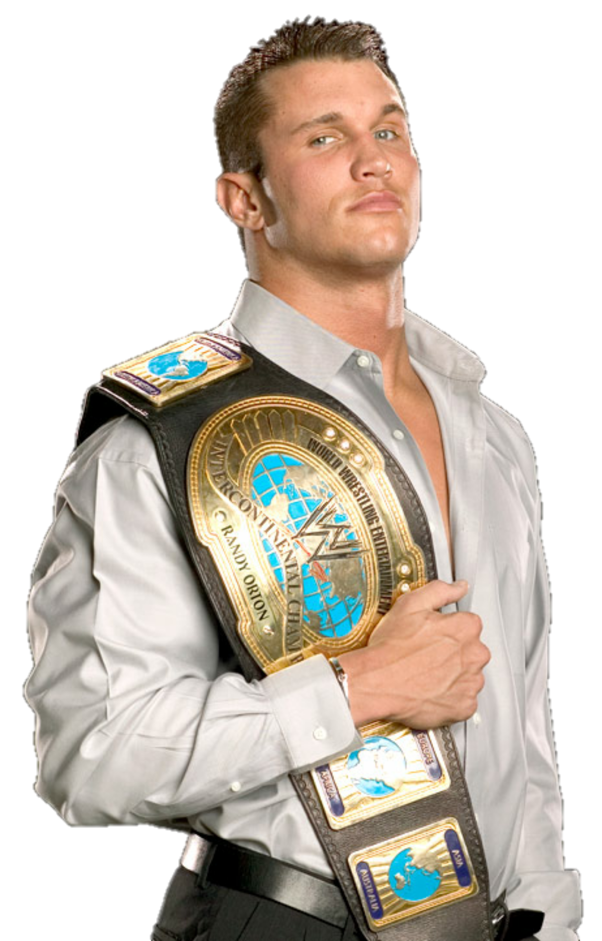 WWE wrestler posing for a sports promo, wearing a gold championship belt slung over his shoulder and a light dress shirt.
