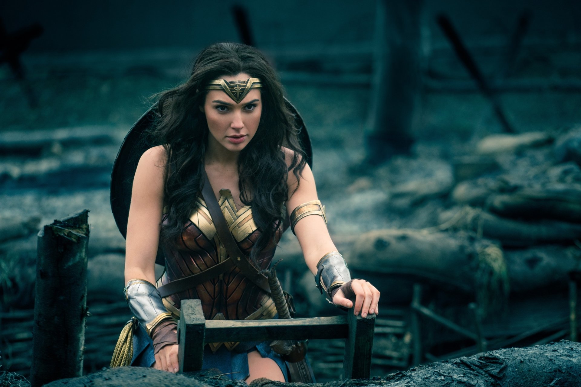 Gal Gadot as Wonder Woman, capturing a moment of intensity in a battle-scarred landscape, showcasing her determination and strength.