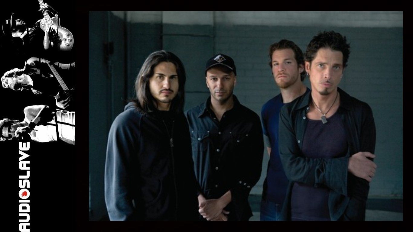 Moody studio portrait of four men standing together in a rock-band promo, tagged Audioslave.