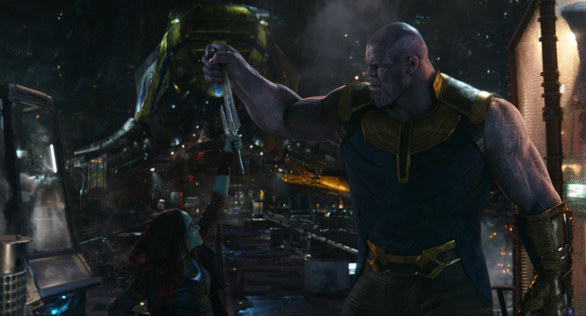 Thanos grips Gamora by the arm aboard his ship in a tense nighttime scene from the movie Avengers: Infinity War.