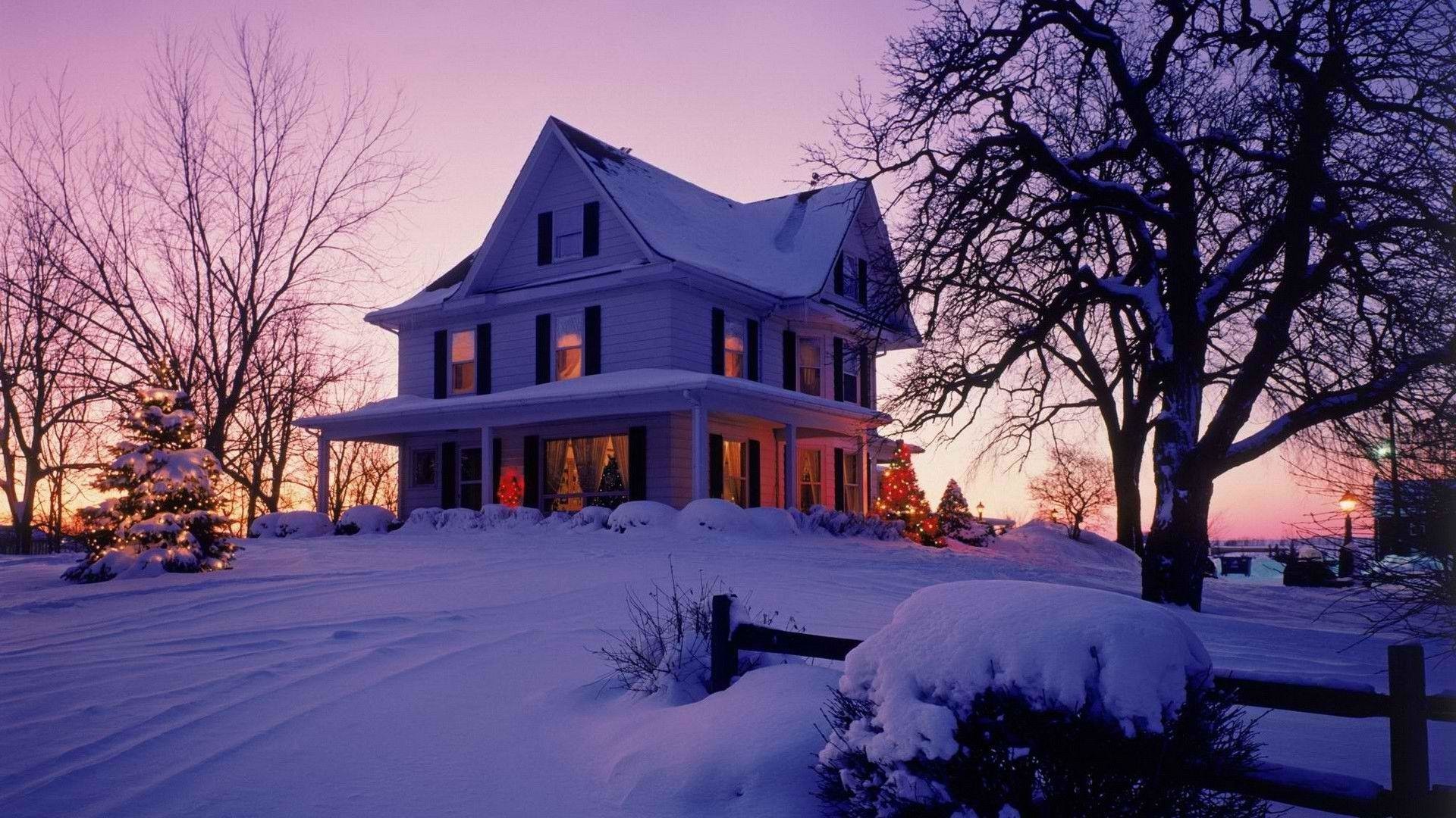 A Victorian house covered in snow during a winter sunset, surrounded by bare trees and a snow-blanketed landscape.