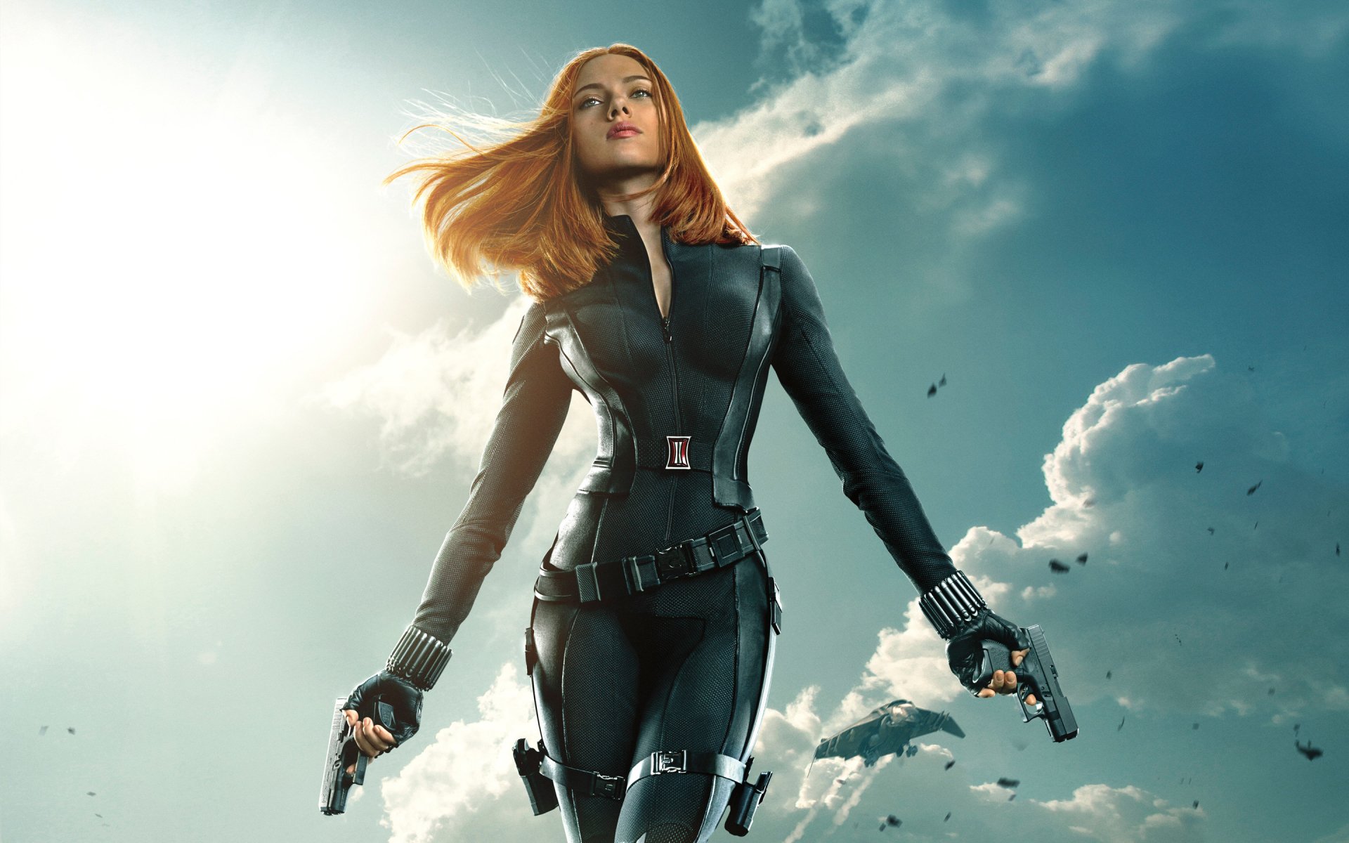 Natasha Romanoff, portrayed by Scarlett Johansson as Black Widow, stands confidently with guns drawn against a dramatic sky in Captain America: The Winter Soldier.
