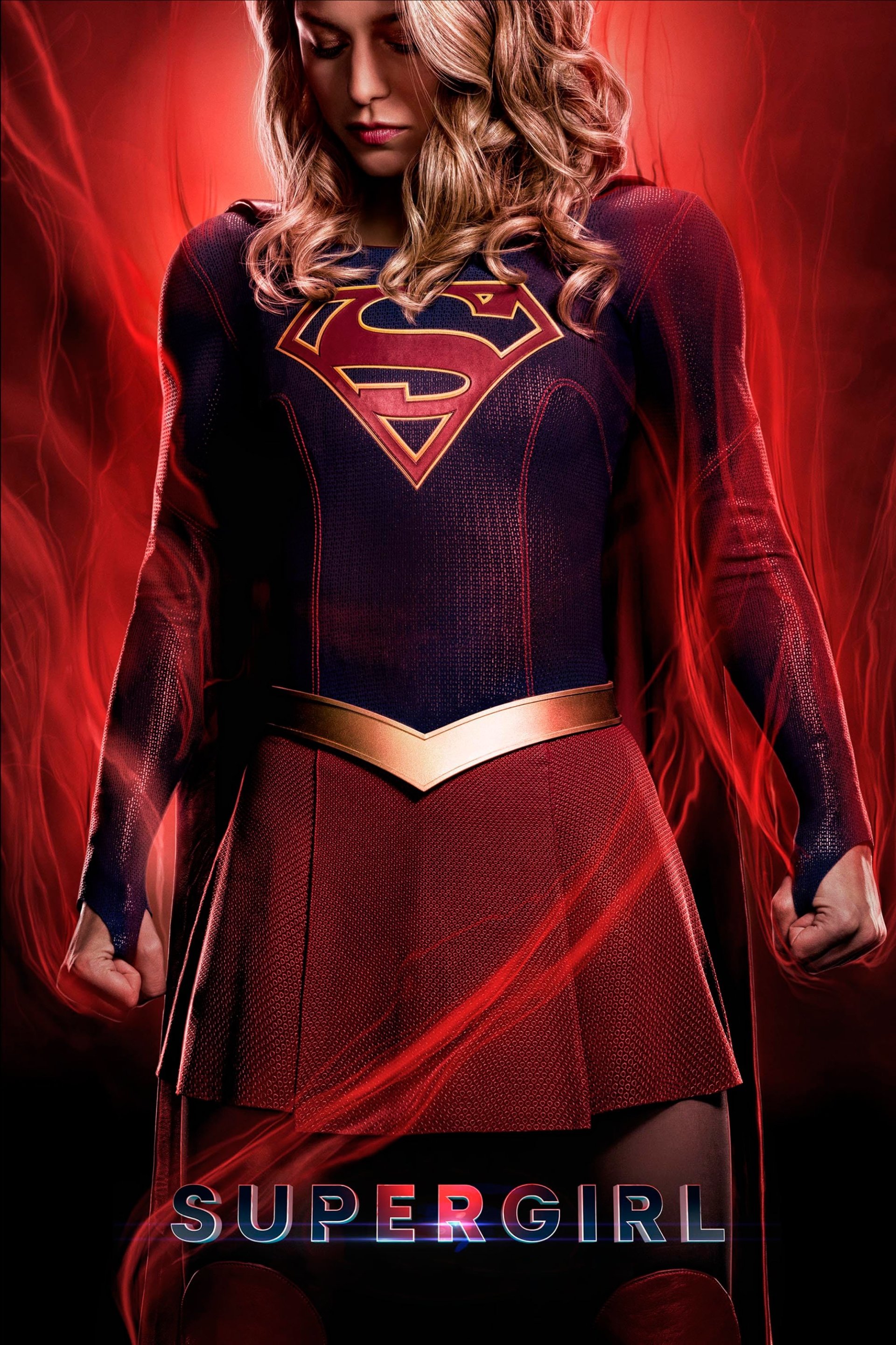 TV show Supergirl promotional image: midshot of Supergirl in a red-and-blue suit with the S emblem, clenched fists and a swirling red energy aura against a dark red background.