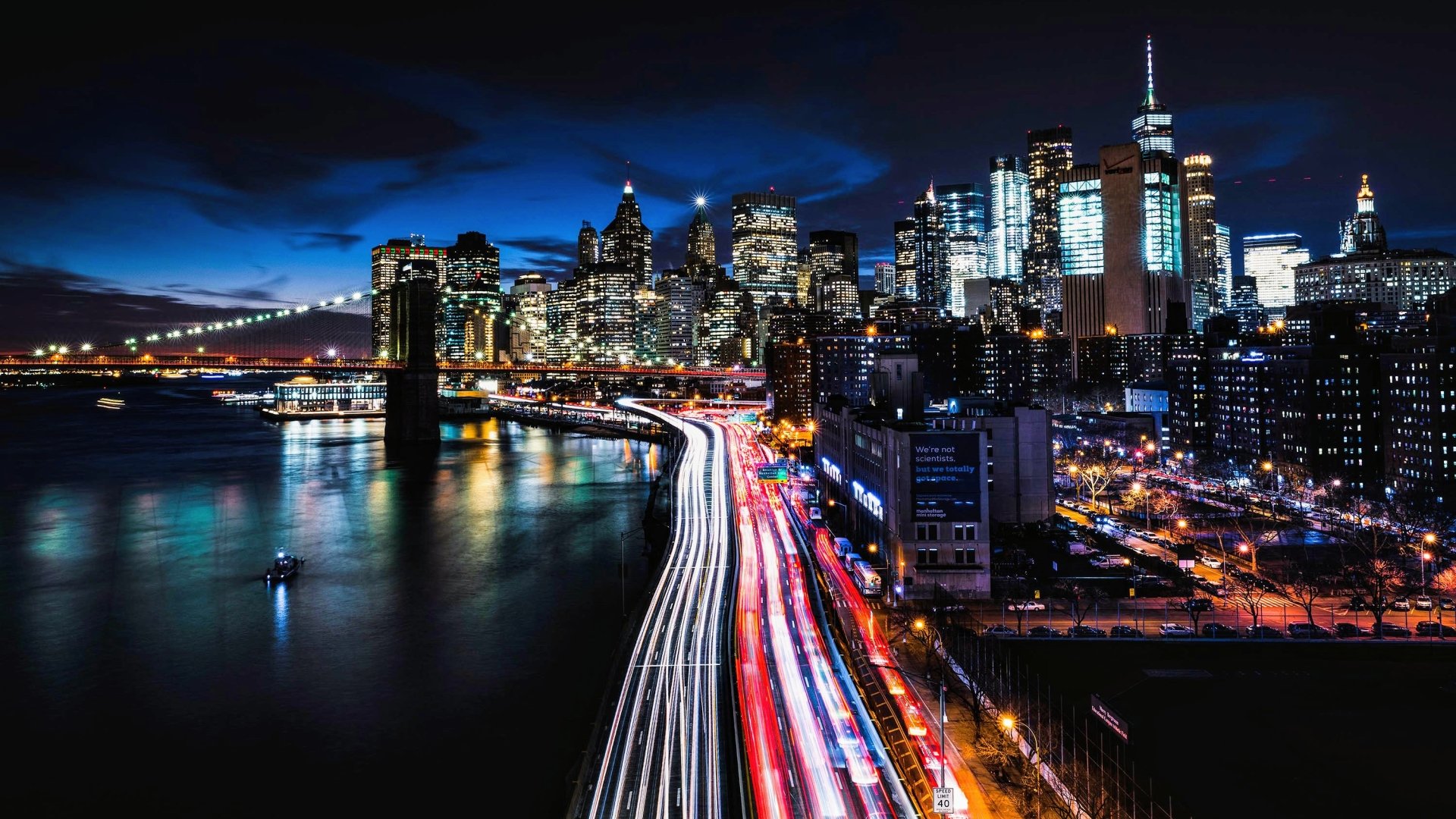 Time-lapse cityscape of New York showcasing the man-made skyline and Brooklyn Bridge with streaking traffic lights along the waterfront.