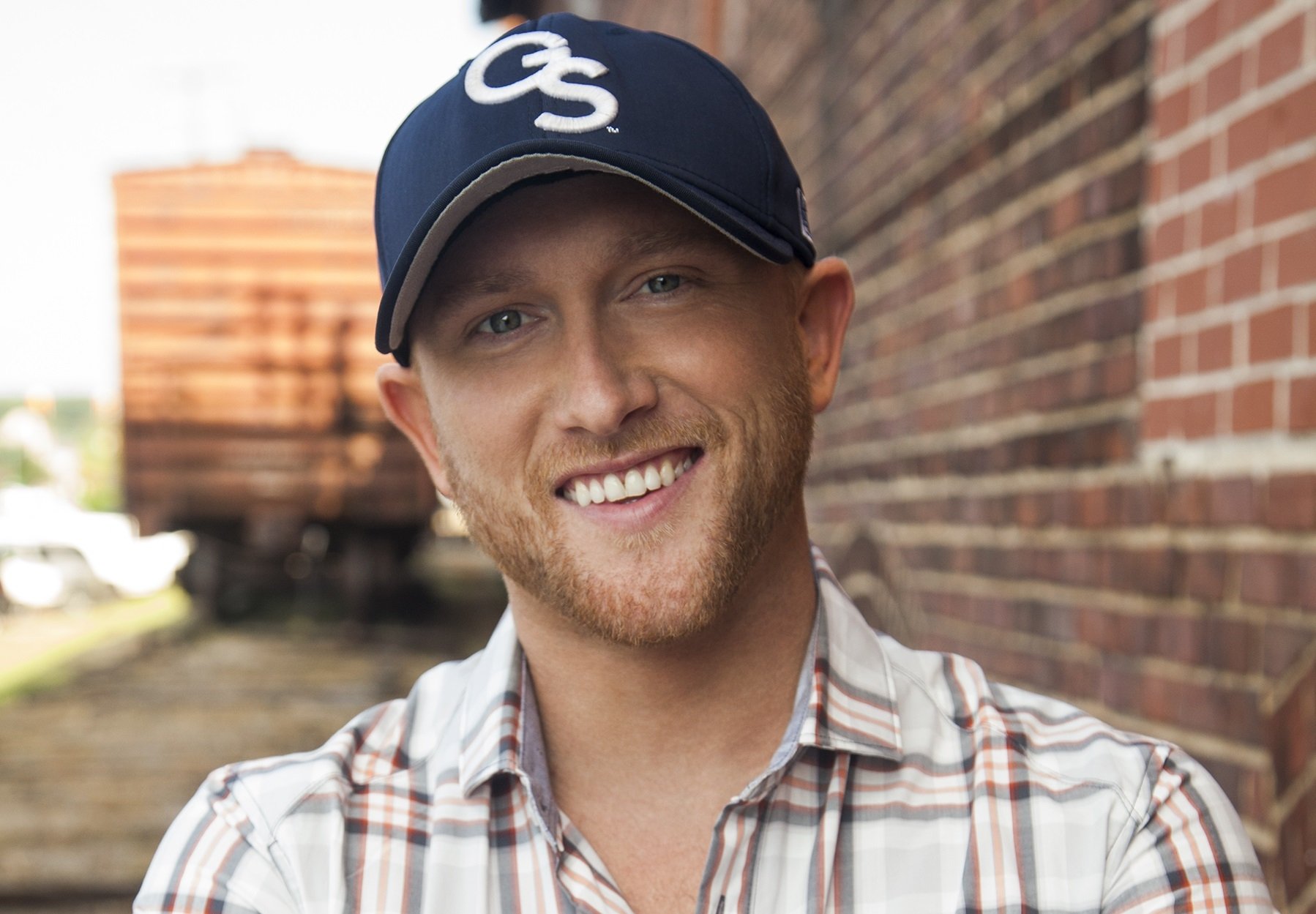 music Cole Swindell smiling man baseball cap plaid shirt Image