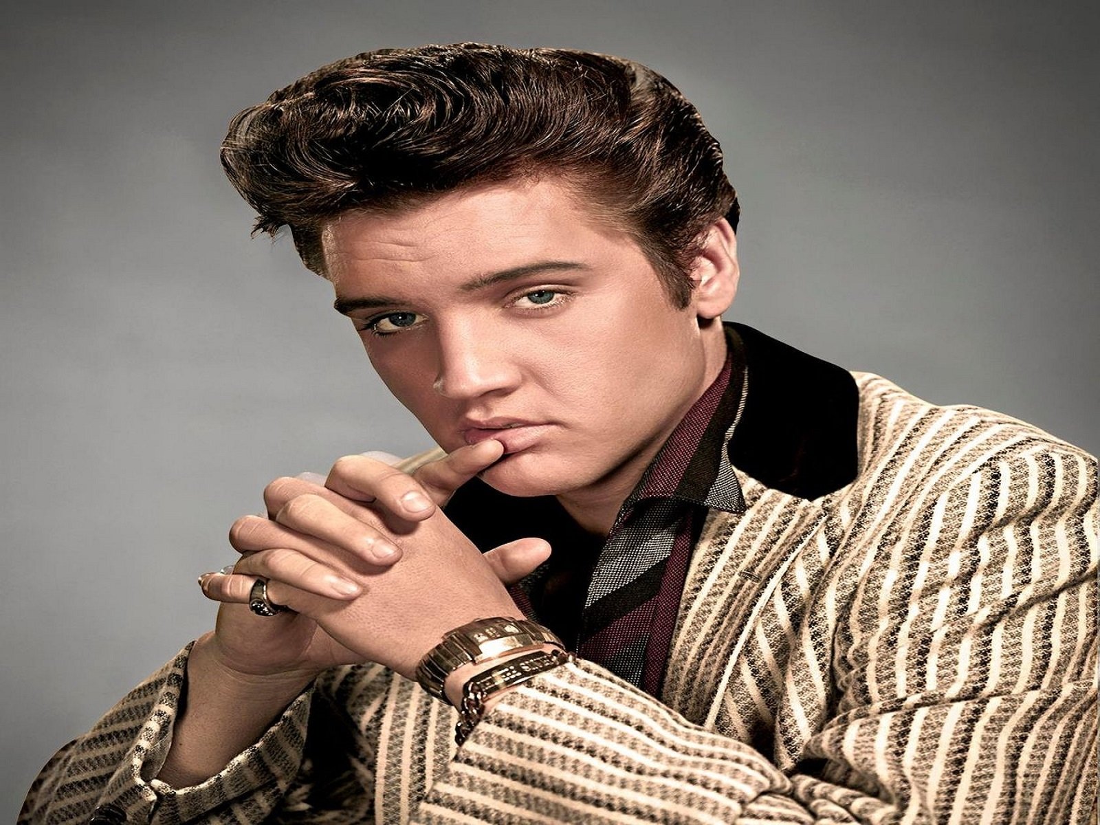 A stylish portrait of Elvis Presley, the iconic figure of rock & roll, showcasing his signature hairstyle and fashion, capturing the essence of his music legacy.