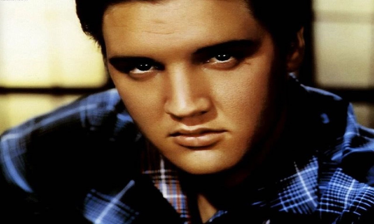 A close-up of Elvis Presley, a legendary figure in Rock & Roll music, showcasing his intense gaze and iconic style.