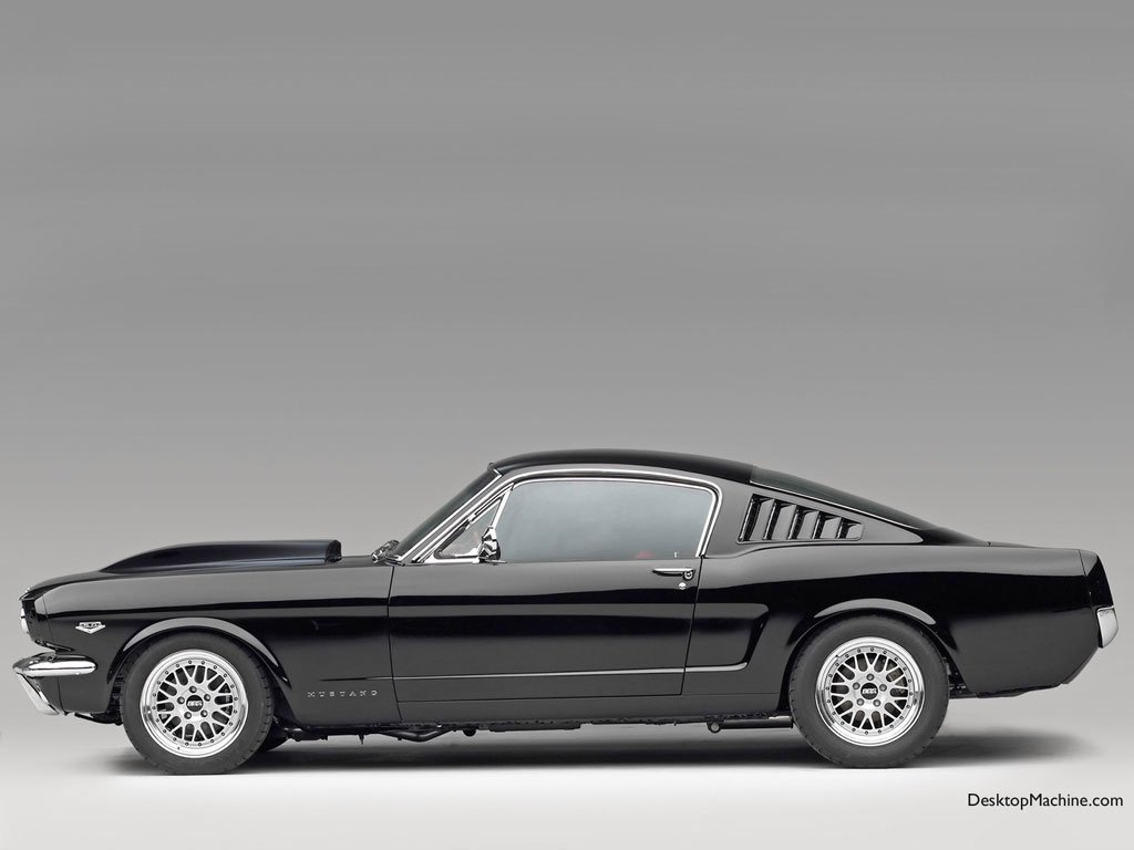 Side view of a classic black Ford Mustang Fastback car showcasing its sleek design and distinctive styling.