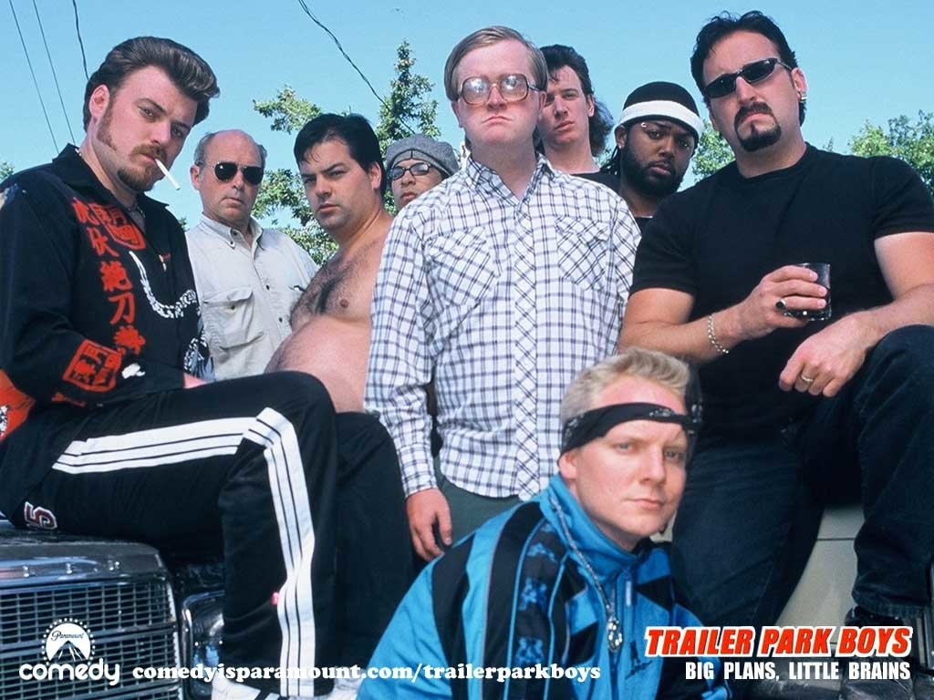 A group of characters from the TV show Trailer Park Boys poses confidently, showcasing their distinct personalities in a vibrant outdoor setting.