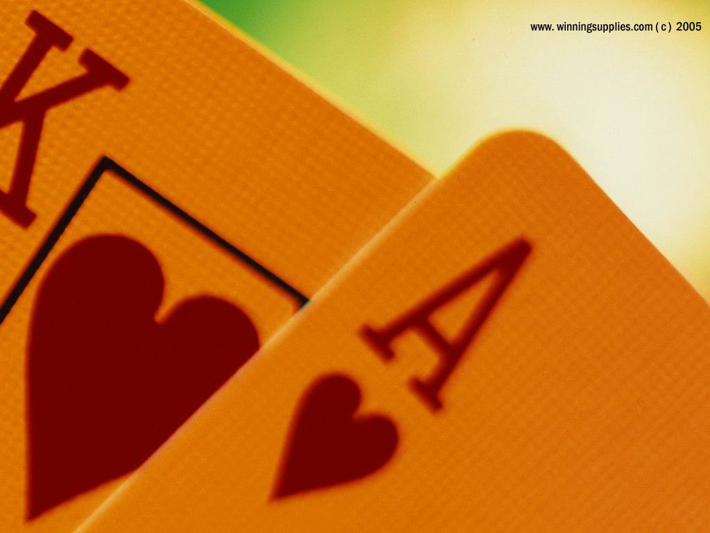 Close-up of two cards showing the King and Ace of hearts, highlighting the man-made design and vivid colors against a blurred background.