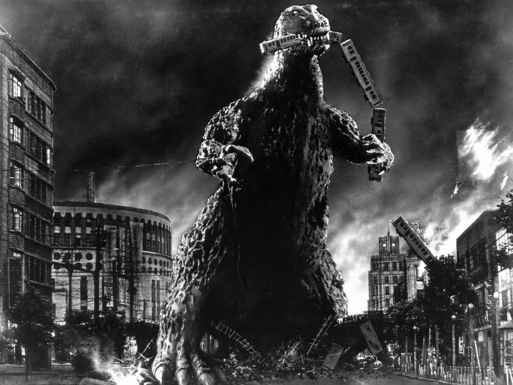 A black and white scene from the 1954 movie Godzilla, featuring the giant creature towering over a city, destroying trains amidst chaos and destruction.