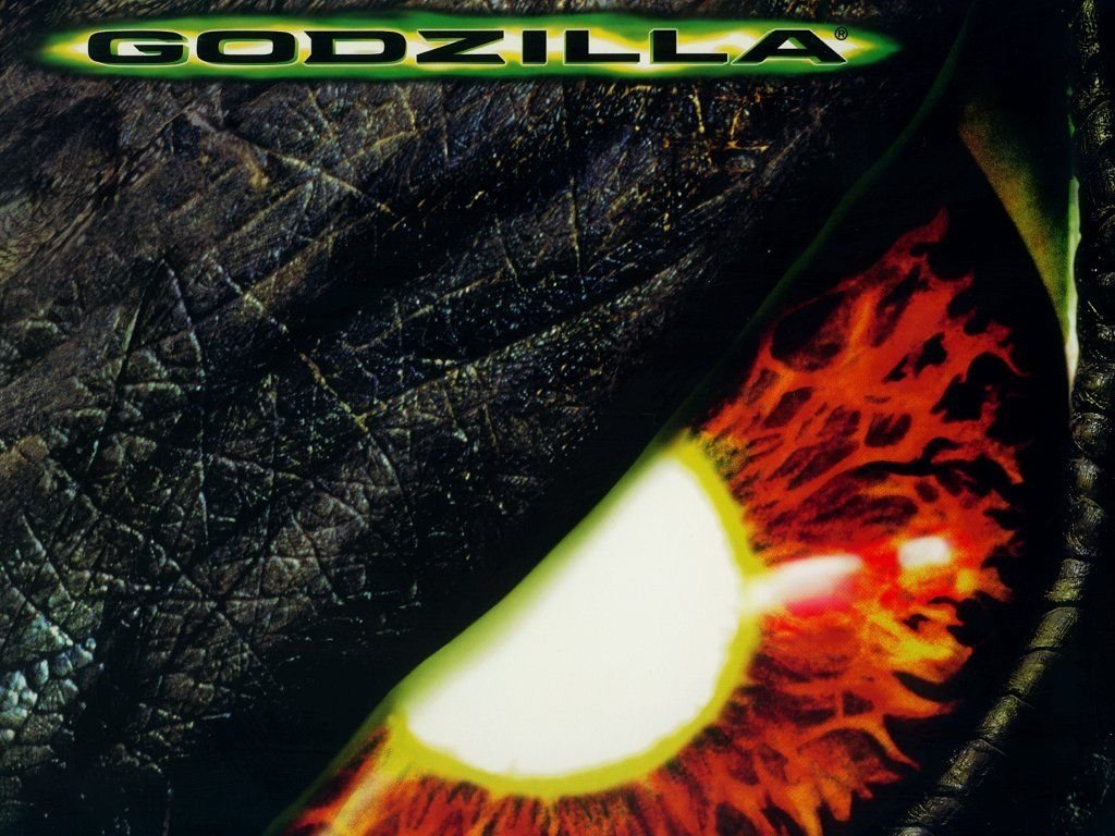 Close-up of Godzilla's eye, featuring intense orange and red hues, from the 1998 TriStar movie Godzilla. The image highlights the creature's imposing presence and iconic design.
