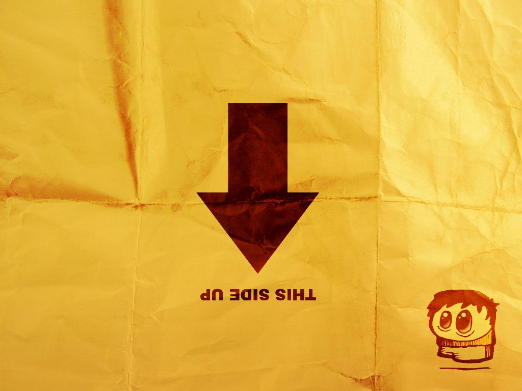 A humorous image featuring a wrinkled yellow background, a downward arrow, and a playful character illustration, with the phrase THIS SIDE UP inverted.