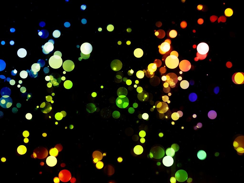 An artistic display of vibrant colors, featuring a dynamic arrangement of bright, circular shapes set against a deep black background.
