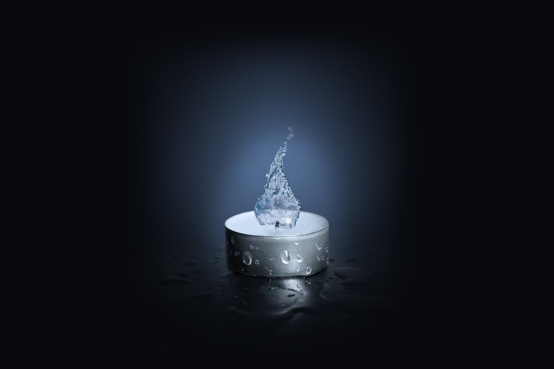 An artistic representation of a candle, featuring a flame-like splash of water, illuminated against a dark background, showcasing elemental themes of fire and water.