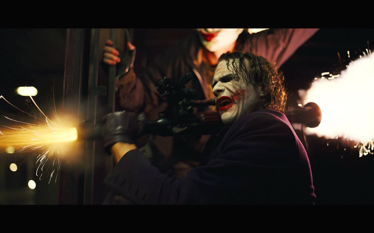 Heath Ledger portrays the Joker in a dramatic scene from *The Dark Knight*, showcasing intense action amid chaos and gunfire.