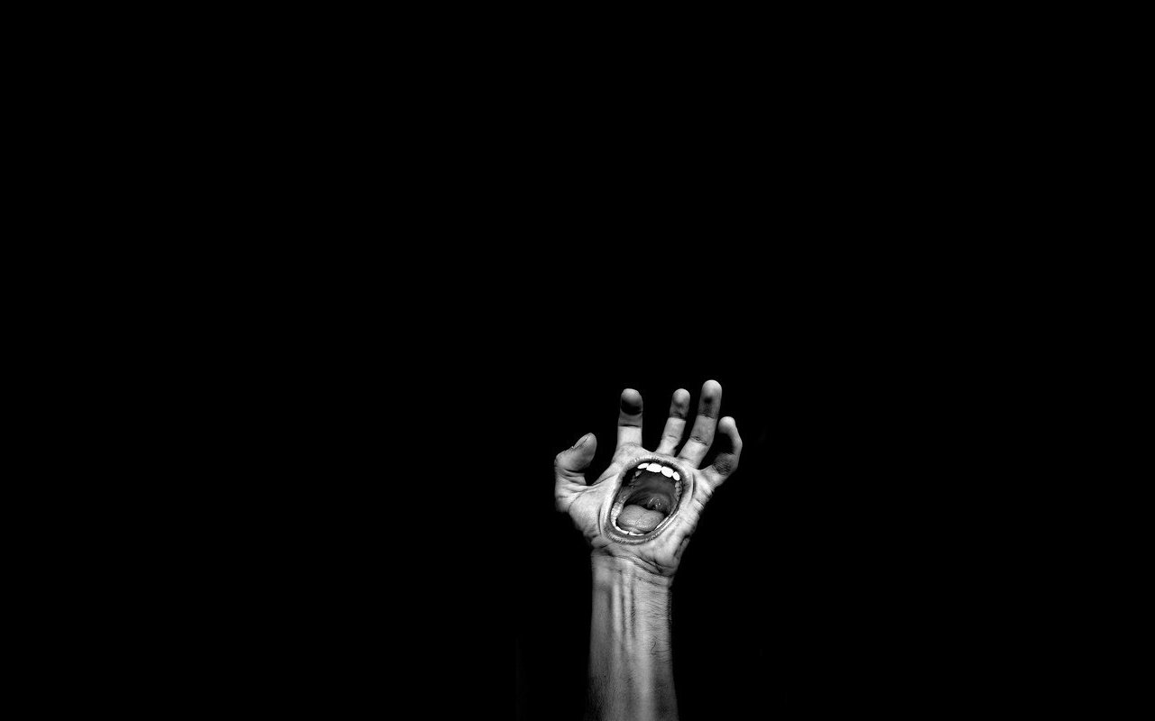 A ghostly hand reaches upward from the darkness, its mouth open in a silent scream, creating an unsettling and surreal atmosphere in a deep black space.