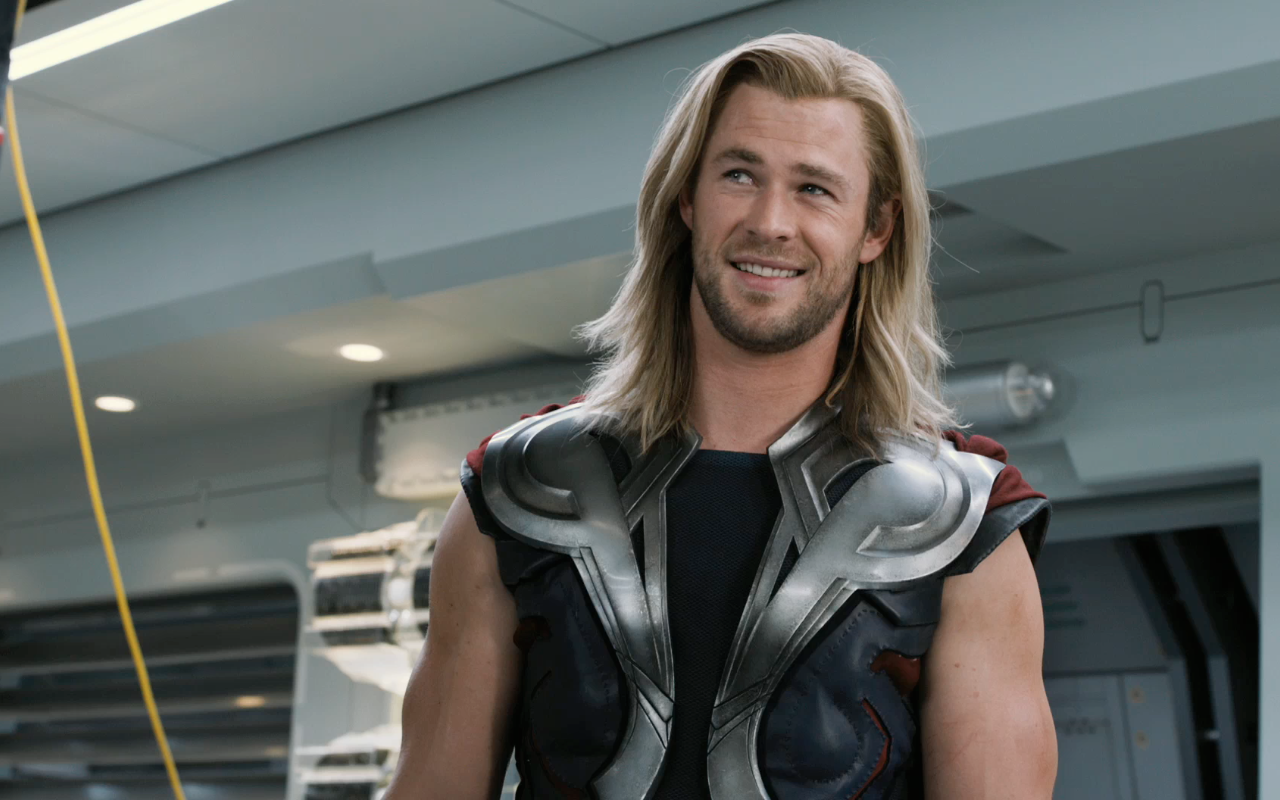 Chris Hemsworth as Thor smiles confidently in a scene from The Avengers, showcasing his iconic armor and charismatic presence in the Marvel universe.