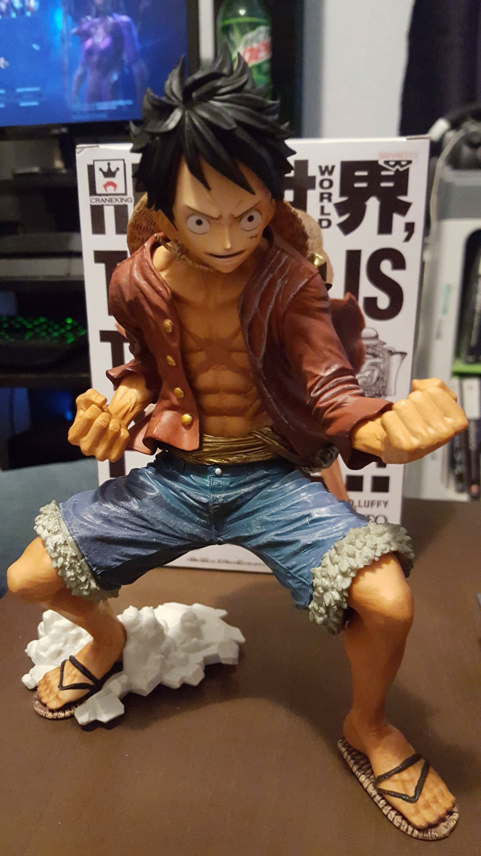 A detailed figure of Luffy from the anime One Piece. He stands in a dynamic pose, ready for action, wearing casual shorts and sandals with a determined expression.