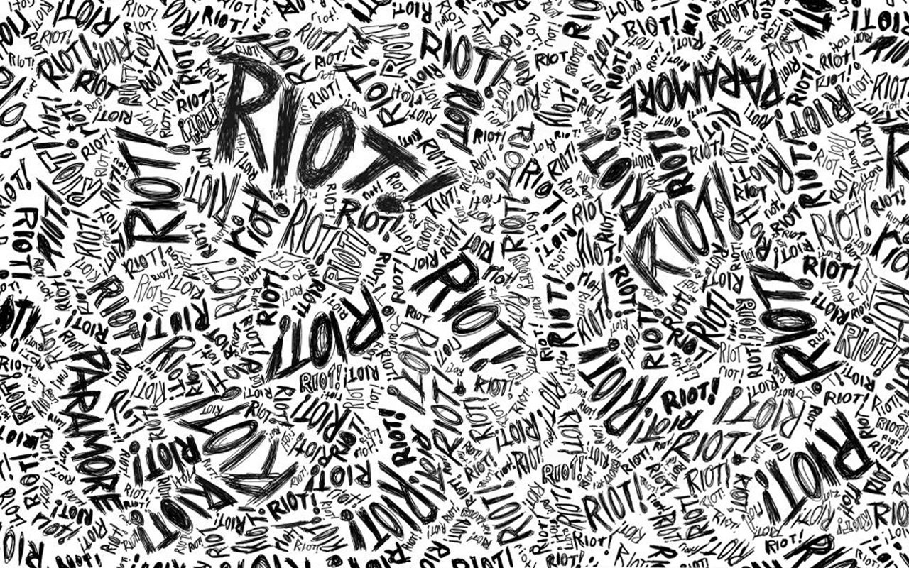 Black-and-white artistic typography collage of the word RIOT repeated in varied fonts and sizes, conveying protest and chaos.