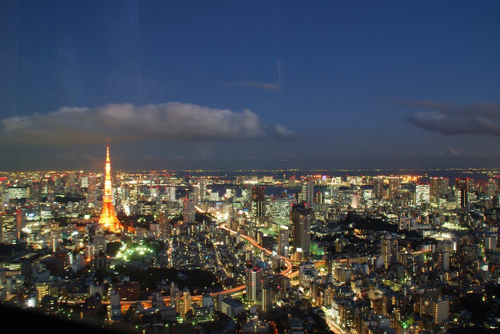 A vibrant city skyline at dusk, showcasing the illuminated Tokyo Tower among a sprawling cityscape, highlighting the beauty of man-made urban architecture.
