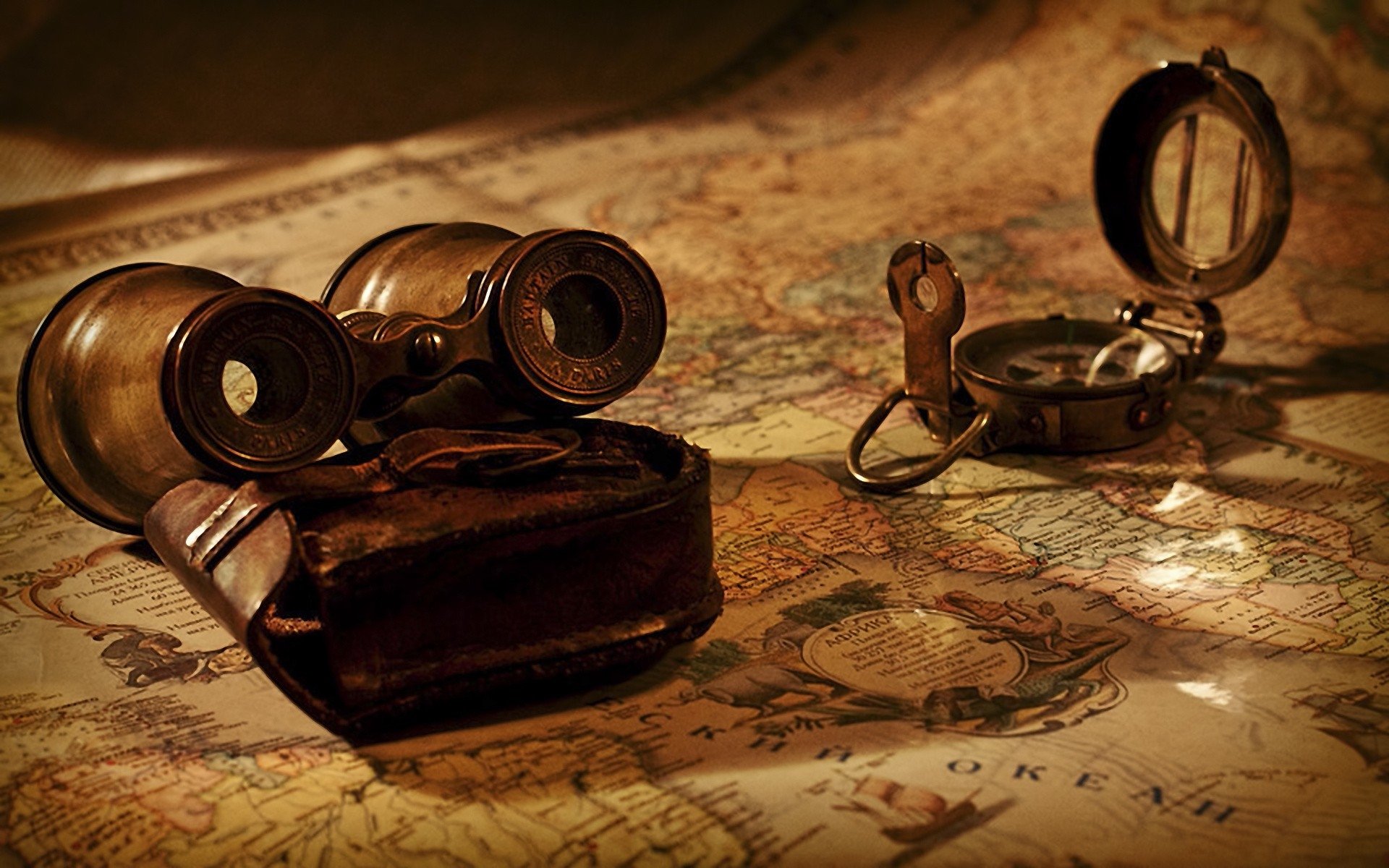 A vintage pair of binoculars and a compass rest on an old military map, highlighting exploration and navigation themes.