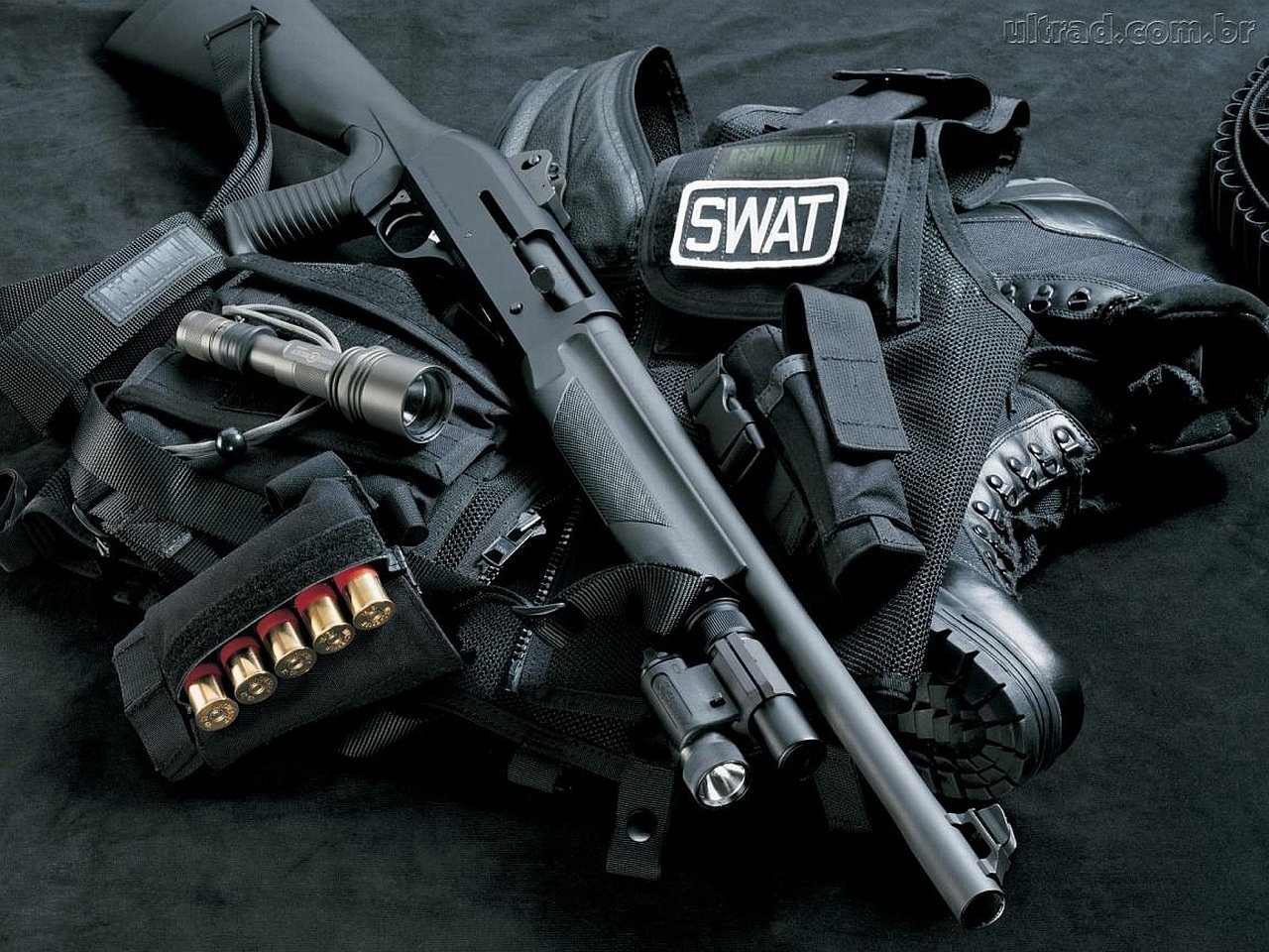 Tactical military and SWAT gear laid out, including a shotgun, boots, gloves, ammunition, and a vest with a SWAT patch on a dark background.