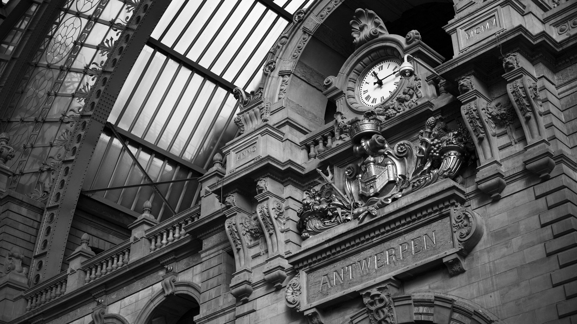 A close-up view of a beautifully detailed man-made building featuring an ornate clock and architectural embellishments, illuminated by natural light streaming through glass.