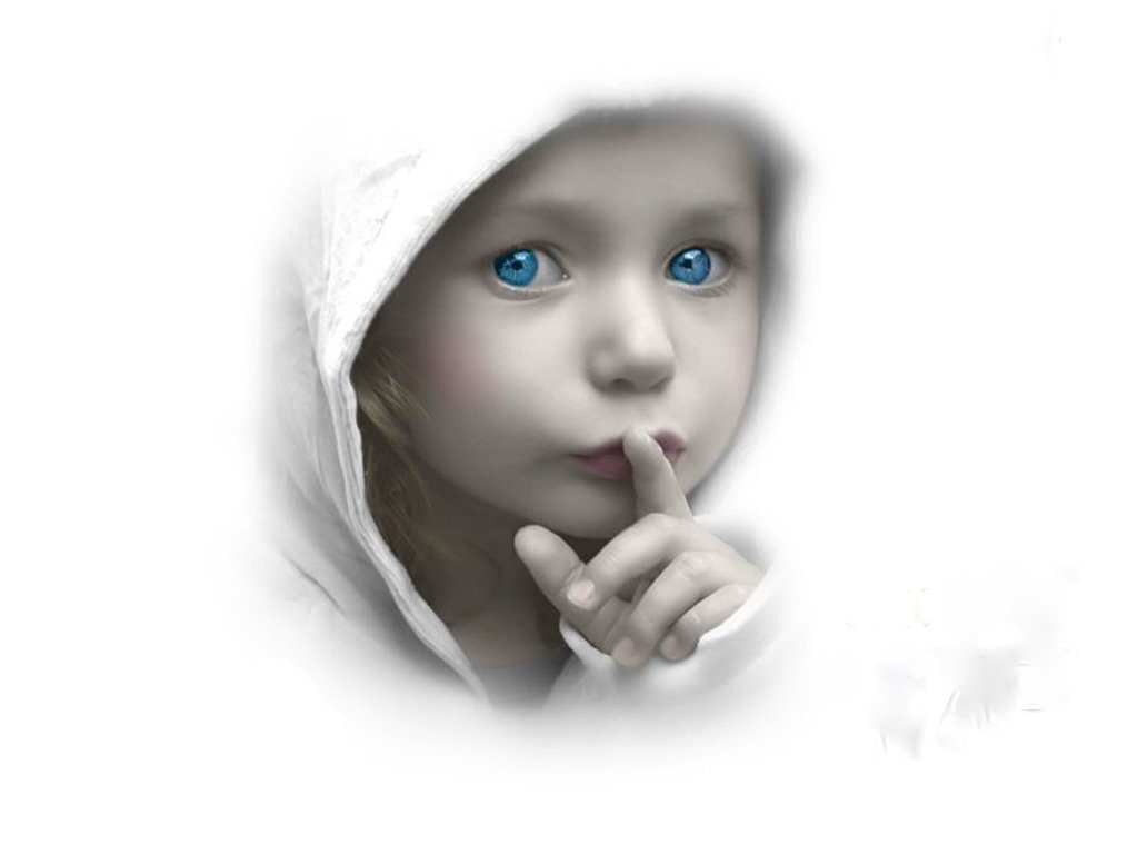 A child with striking blue eyes and a finger pressed to their lips, wearing a white hood, evokes a sense of mystery and calm in this captivating photography.