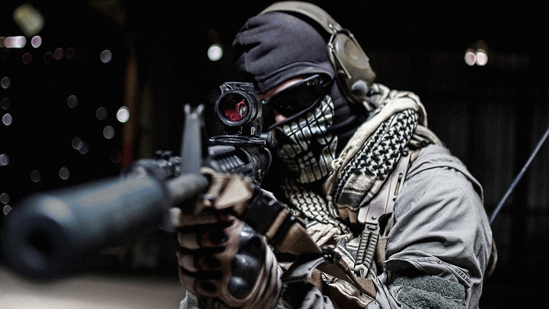 A military soldier wearing tactical gear and a skull-patterned face mask aims a rifle equipped with a scope and suppressor in a low-light environment.