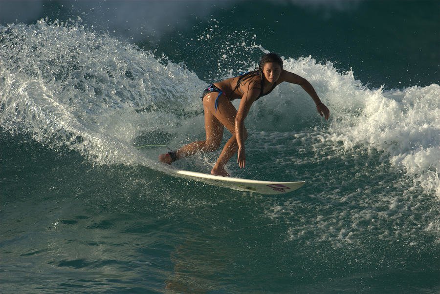 A person skillfully surfing on a wave, showcasing balance and agility in the sport of surfing.