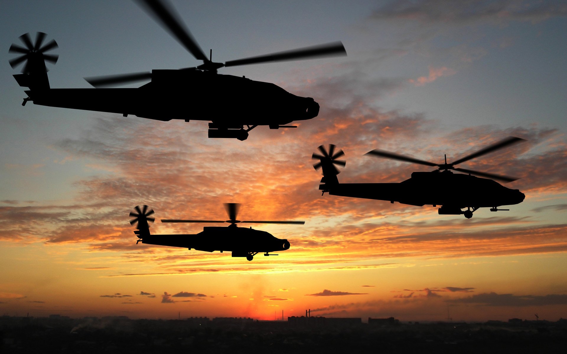 Three military Boeing AH-64 Apache helicopters fly silhouetted against a colorful sunset sky.