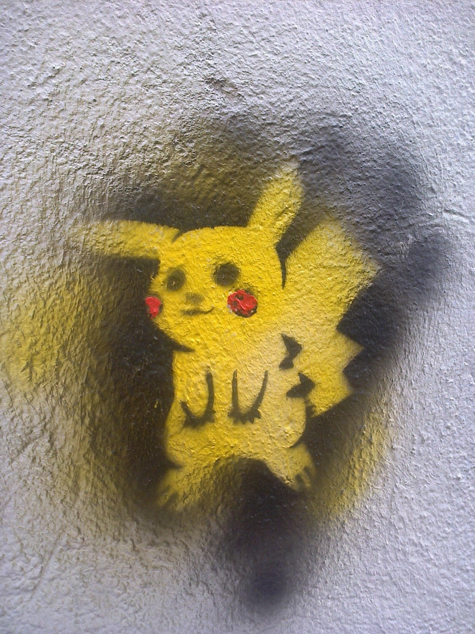 A vibrant graffiti artwork featuring Pikachu, showcasing its iconic yellow color and playful design against a textured wall background.