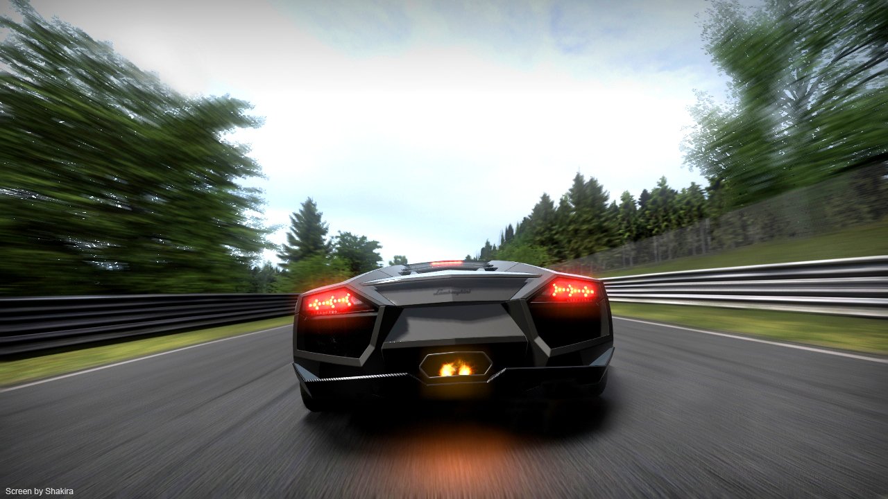 Rear view of a black supercar racing down a tree-lined track in the video game Gran Turismo 6, motion blur and glowing exhaust emphasizing high speed.