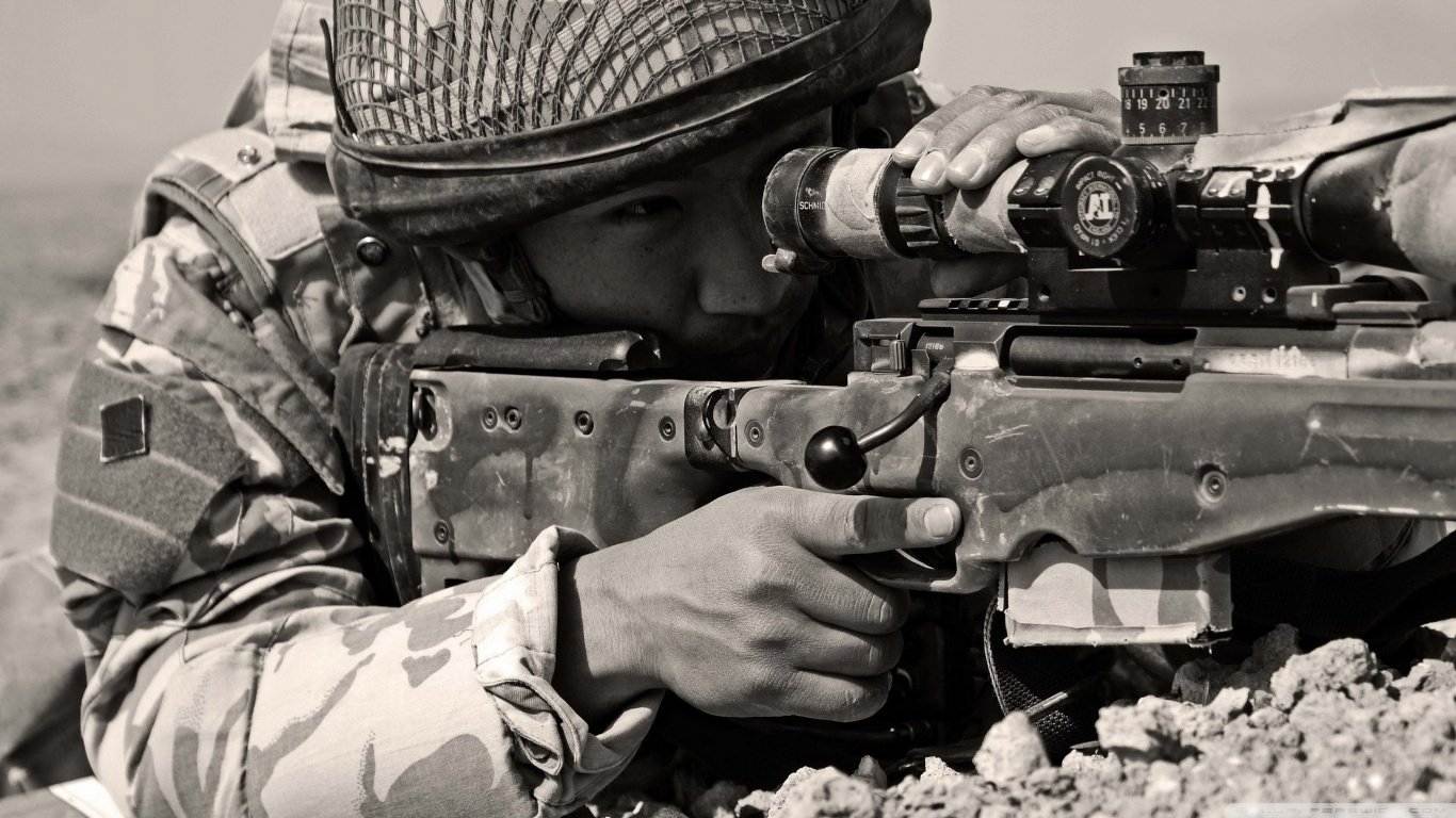 A military sniper in camouflage gear focuses intently through the scope of a rifle, poised in a rugged landscape, ready for action.