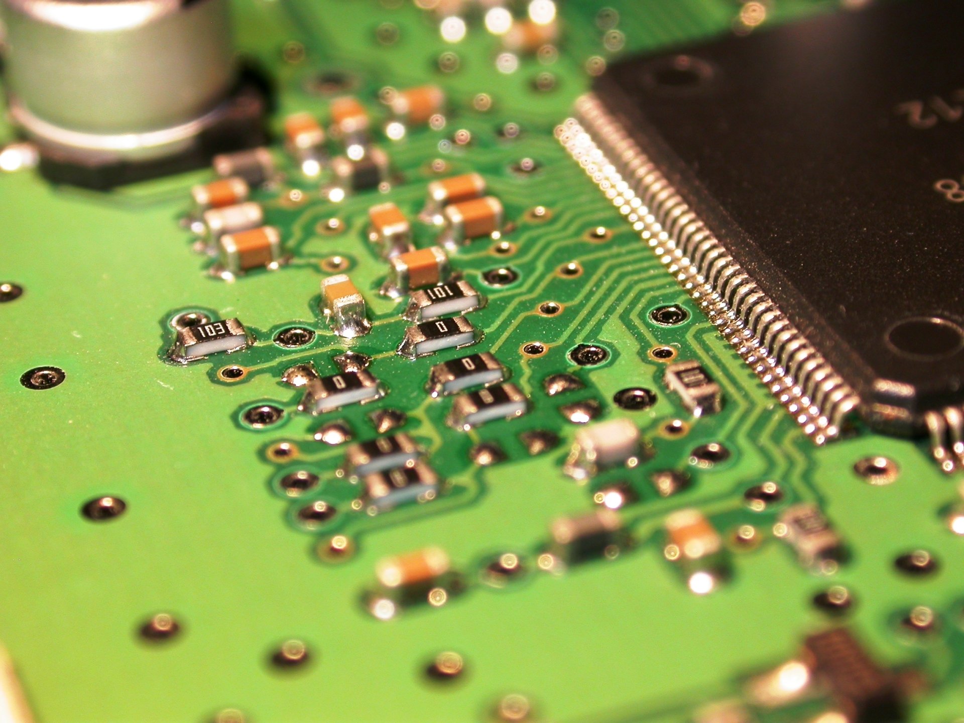 Close-up of a circuit board showcasing intricate electronic components and traces, highlighting the complexity of technology.