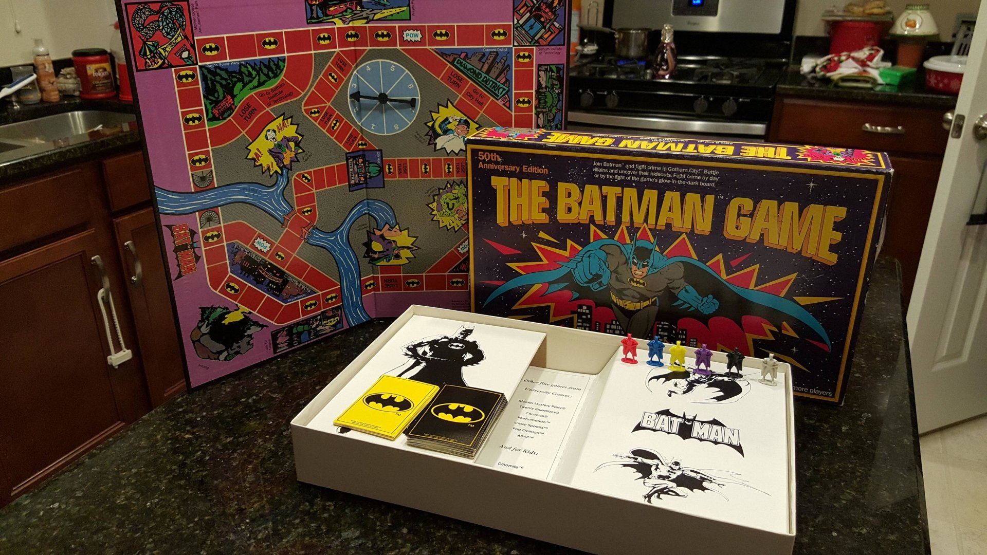 Man-made board game setup of The Batman Game displayed on a kitchen countertop with colorful game pieces and illustrated board sections.