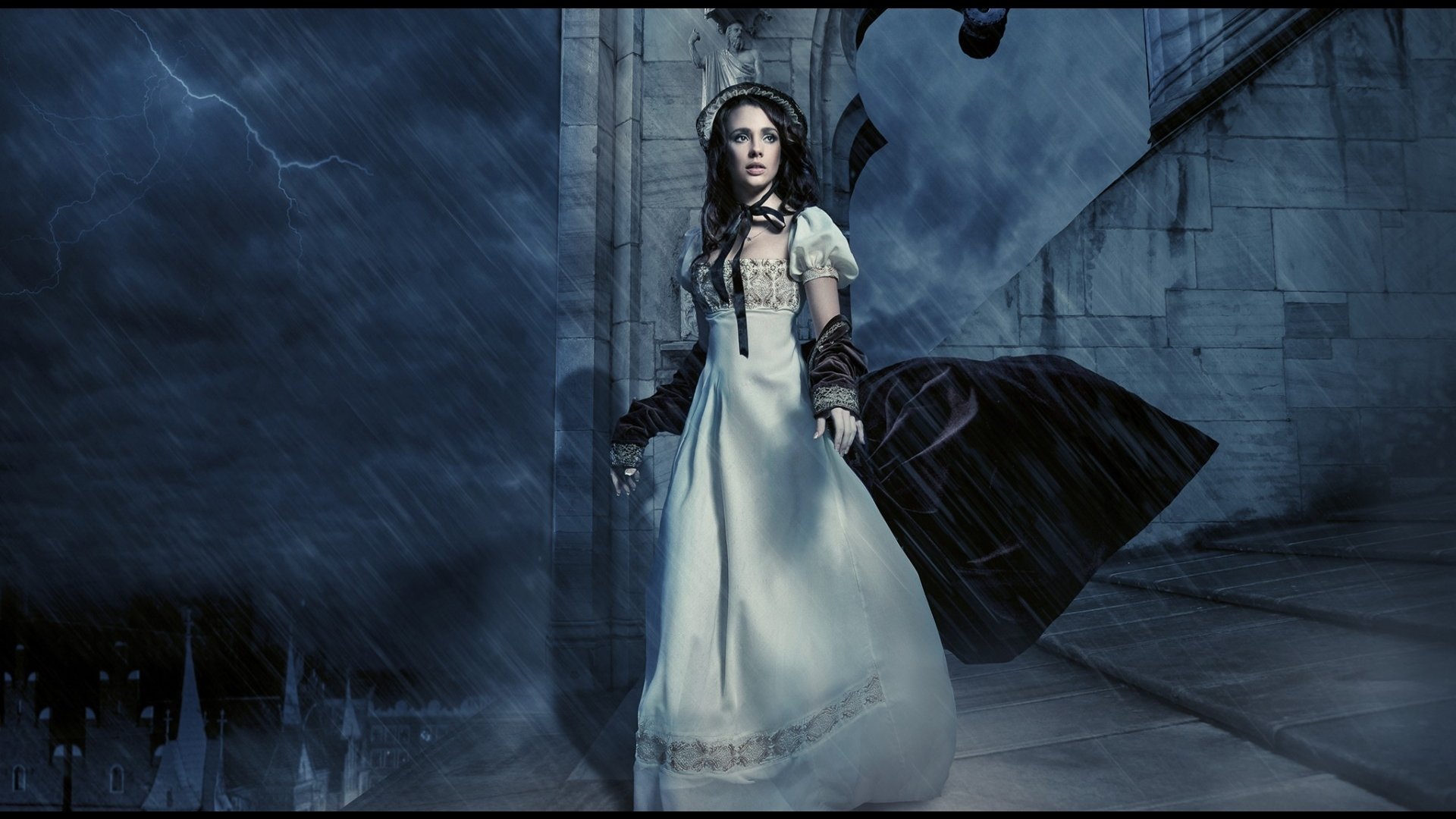 An artistic image of a woman in a flowing white dress standing in a dark, stormy, and gothic setting with a dramatic black cloak billowing behind her.