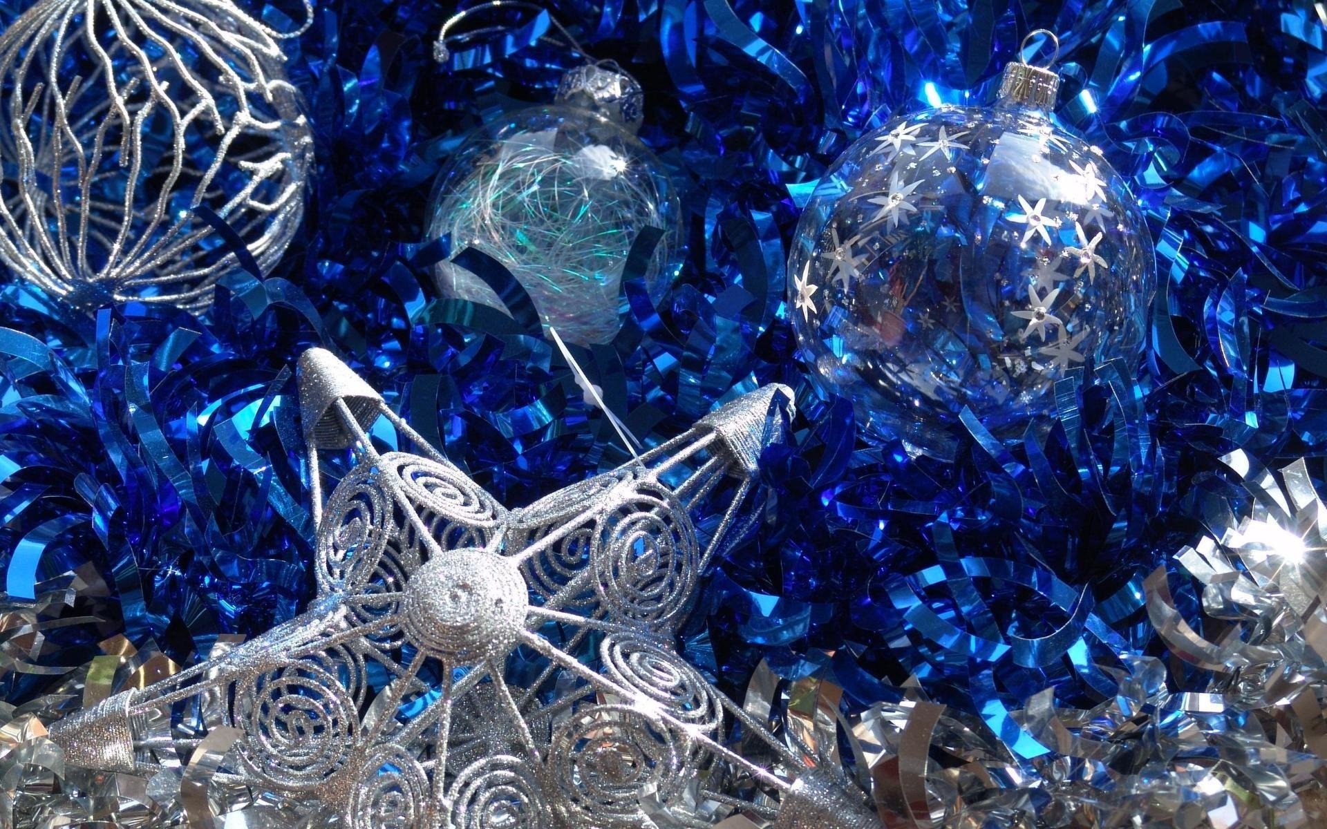 Silver and blue Christmas ornaments: glittering baubles, a filigree star and shimmering tinsel arranged for the holiday.