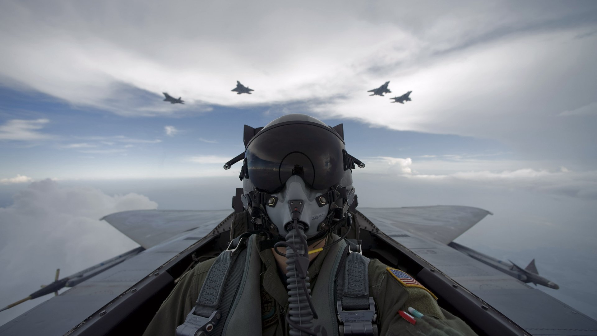 A soldier in a flight suit piloting a military jet, with multiple fighter jets flying in formation above amidst a cloudy sky.