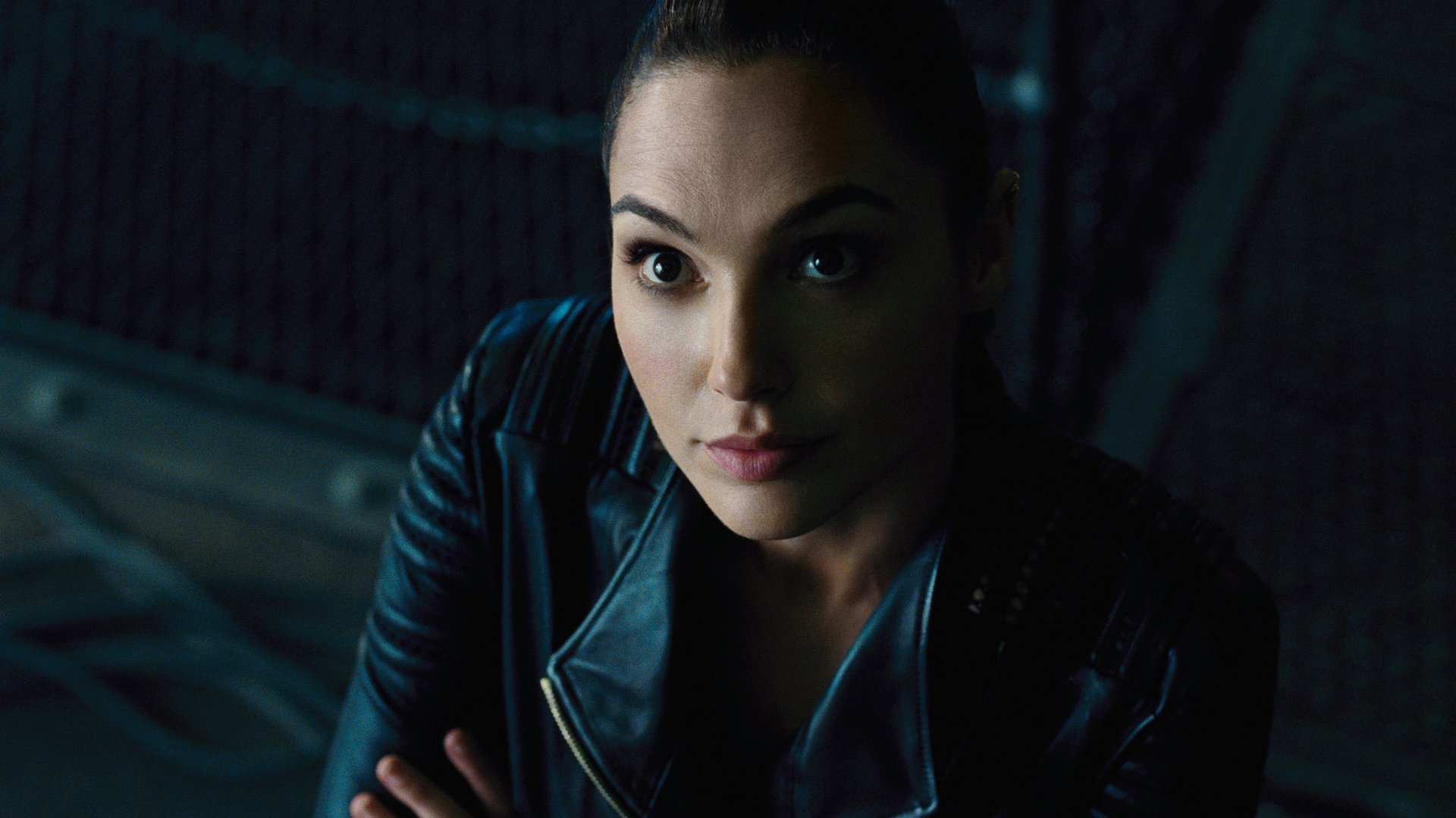 Diana Prince as Wonder Woman in a scene from the 2017 movie Justice League, wearing a black leather jacket and looking intently ahead.