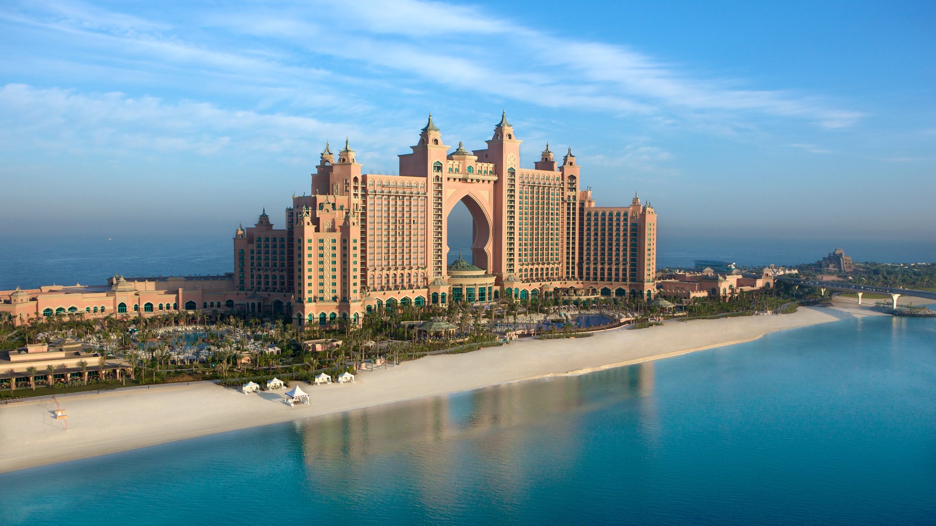 The Atlantis, The Palm hotel in Dubai stands prominently on the man-made Palm Jumeirah island, overlooking a pristine beach and calm blue waters.