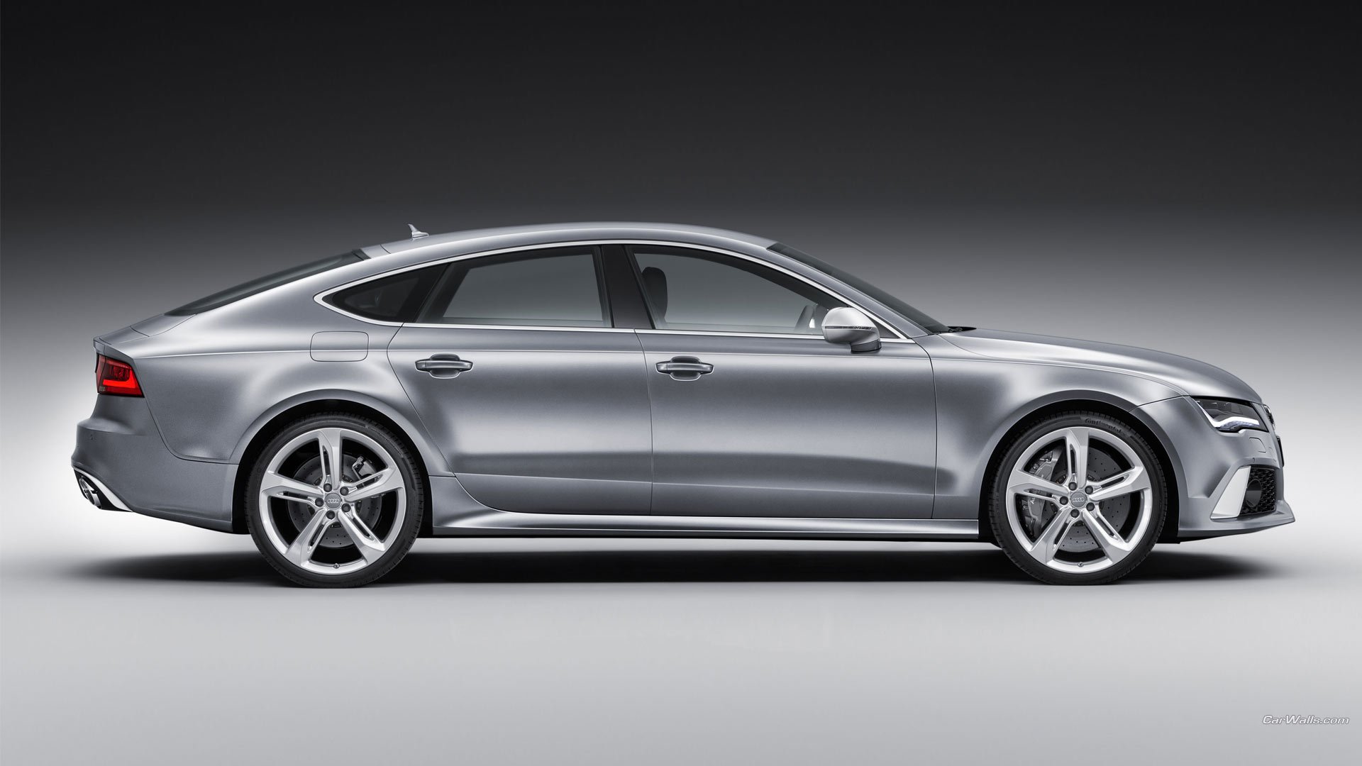 Side view of a sleek silver Audi RS7 vehicle showcased against a neutral gray background.